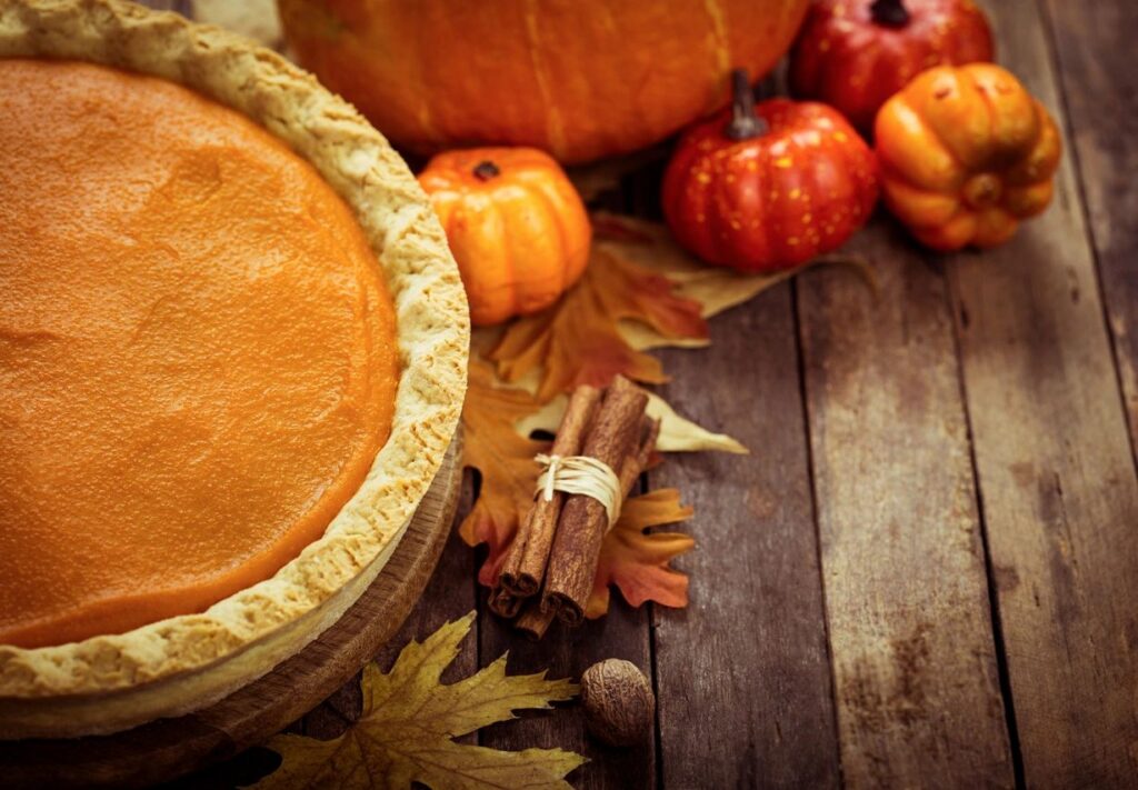 Pumpkin pie display with mini pumpkins and fall leaves