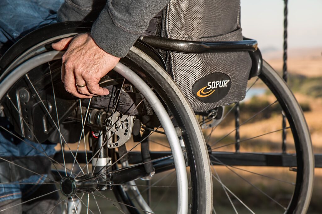 Close-up of a man in a wheelchair. One hand on the wheel.